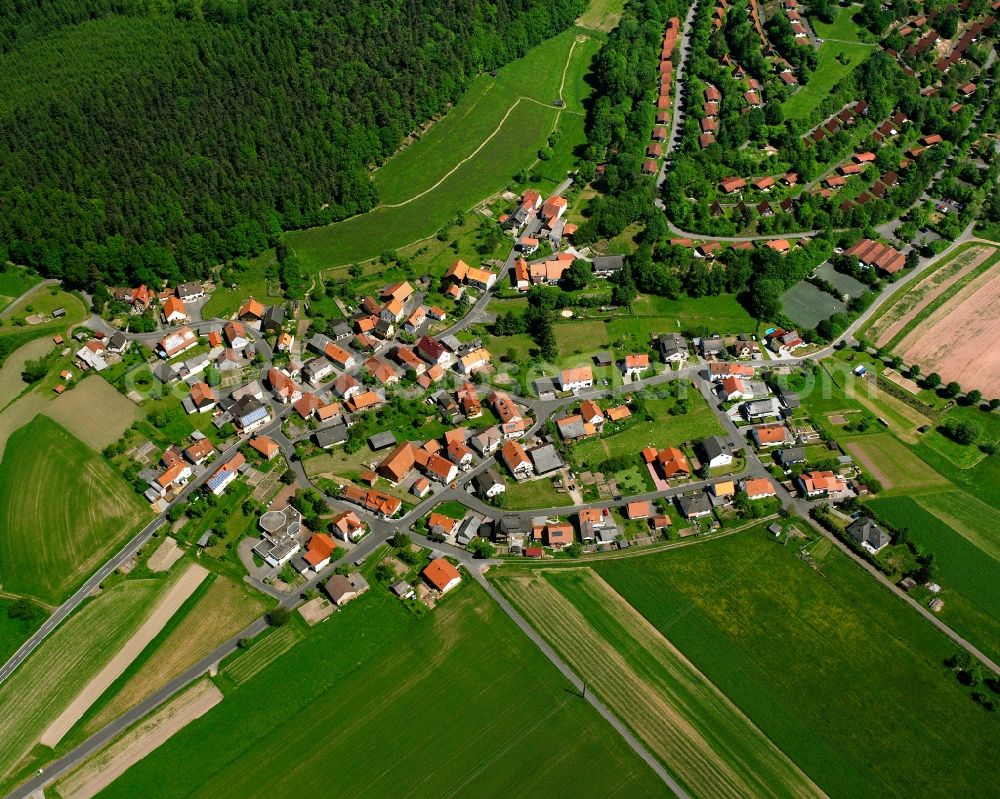 Machtlos from above - Agricultural land and field boundaries surround the settlement area of the village in Machtlos in the state Hesse, Germany