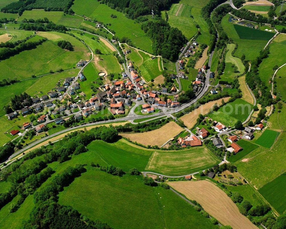 Aerial photograph Malkomes - Agricultural land and field boundaries surround the settlement area of the village in Malkomes in the state Hesse, Germany