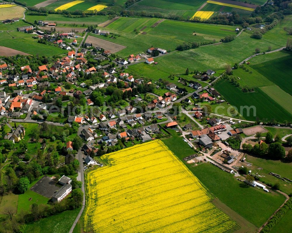 Mansbach from the bird's eye view: Agricultural land and field boundaries surround the settlement area of the village in Mansbach in the state Hesse, Germany