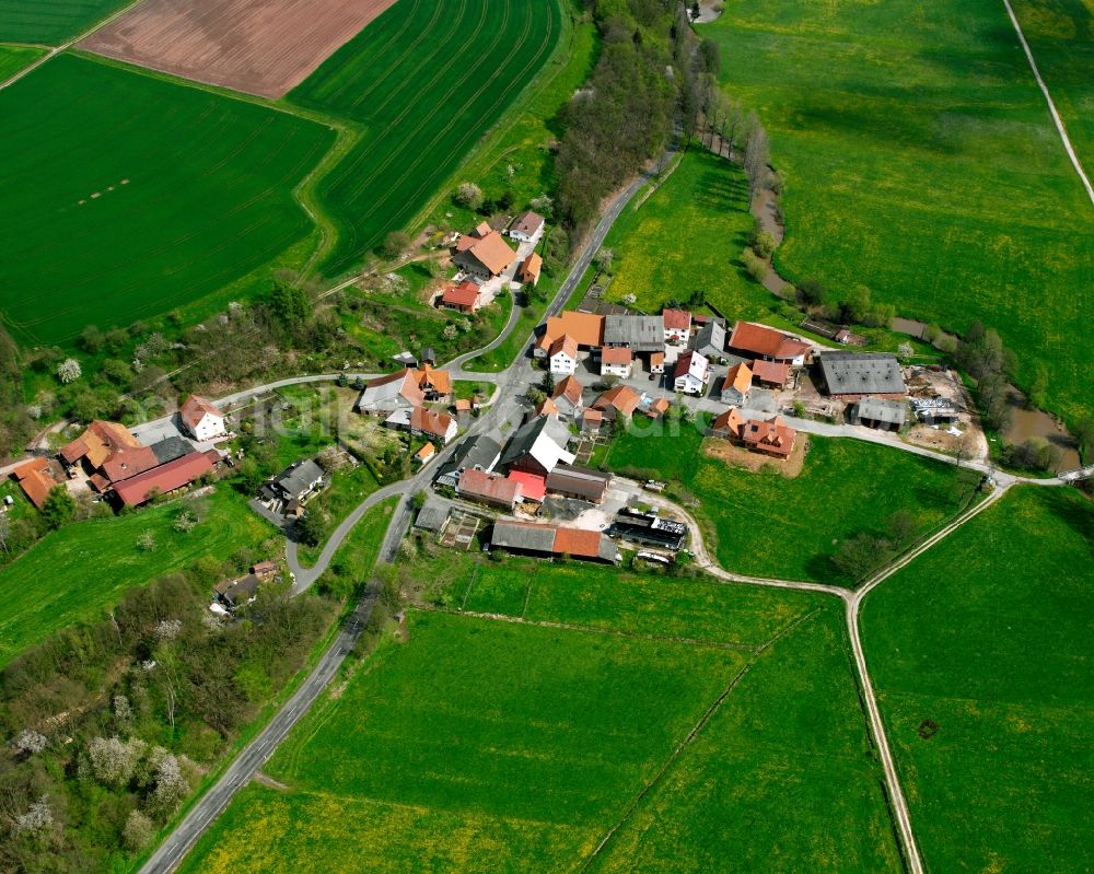 Mauers from the bird's eye view: Agricultural land and field boundaries surround the settlement area of the village in Mauers in the state Hesse, Germany