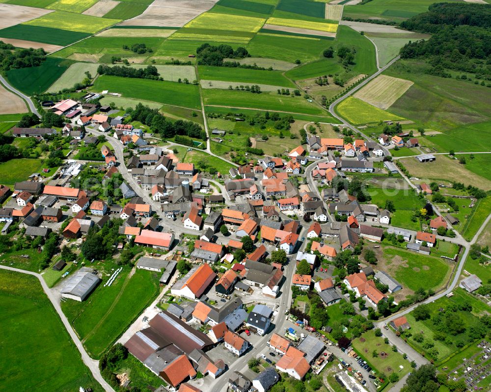 Aerial photograph Maulbach - Agricultural land and field boundaries surround the settlement area of the village in Maulbach in the state Hesse, Germany