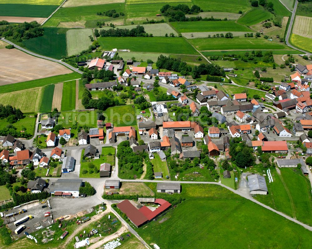 Maulbach from above - Agricultural land and field boundaries surround the settlement area of the village in Maulbach in the state Hesse, Germany