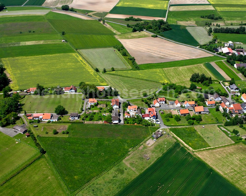 Maulbach from the bird's eye view: Agricultural land and field boundaries surround the settlement area of the village in Maulbach in the state Hesse, Germany