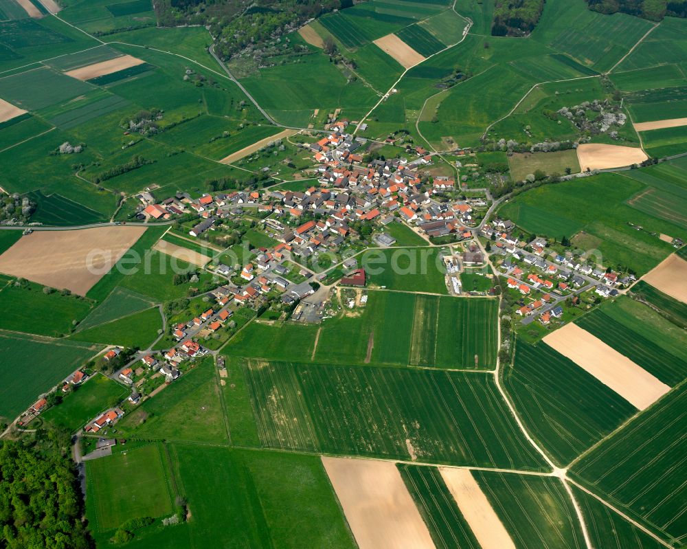 Maulbach from above - Agricultural land and field boundaries surround the settlement area of the village in Maulbach in the state Hesse, Germany