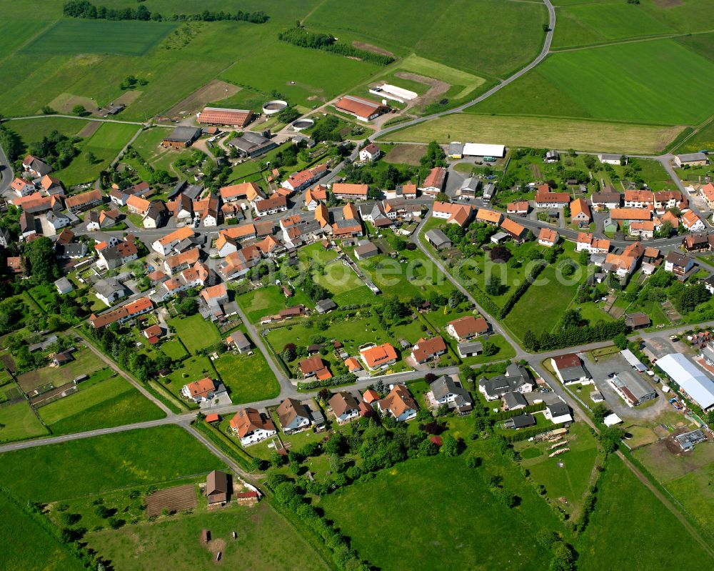 Meiches from above - Agricultural land and field boundaries surround the settlement area of the village in Meiches in the state Hesse, Germany