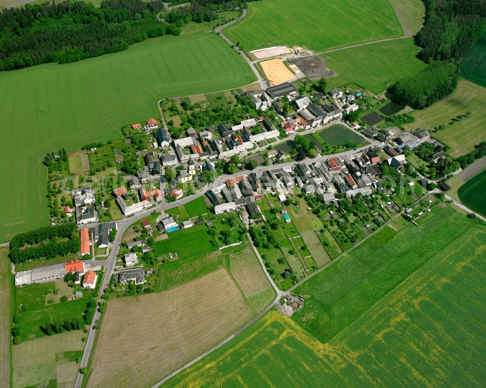 Merkendorf from the bird's eye view: Agricultural land and field boundaries surround the settlement area of the village in Merkendorf in the state Thuringia, Germany