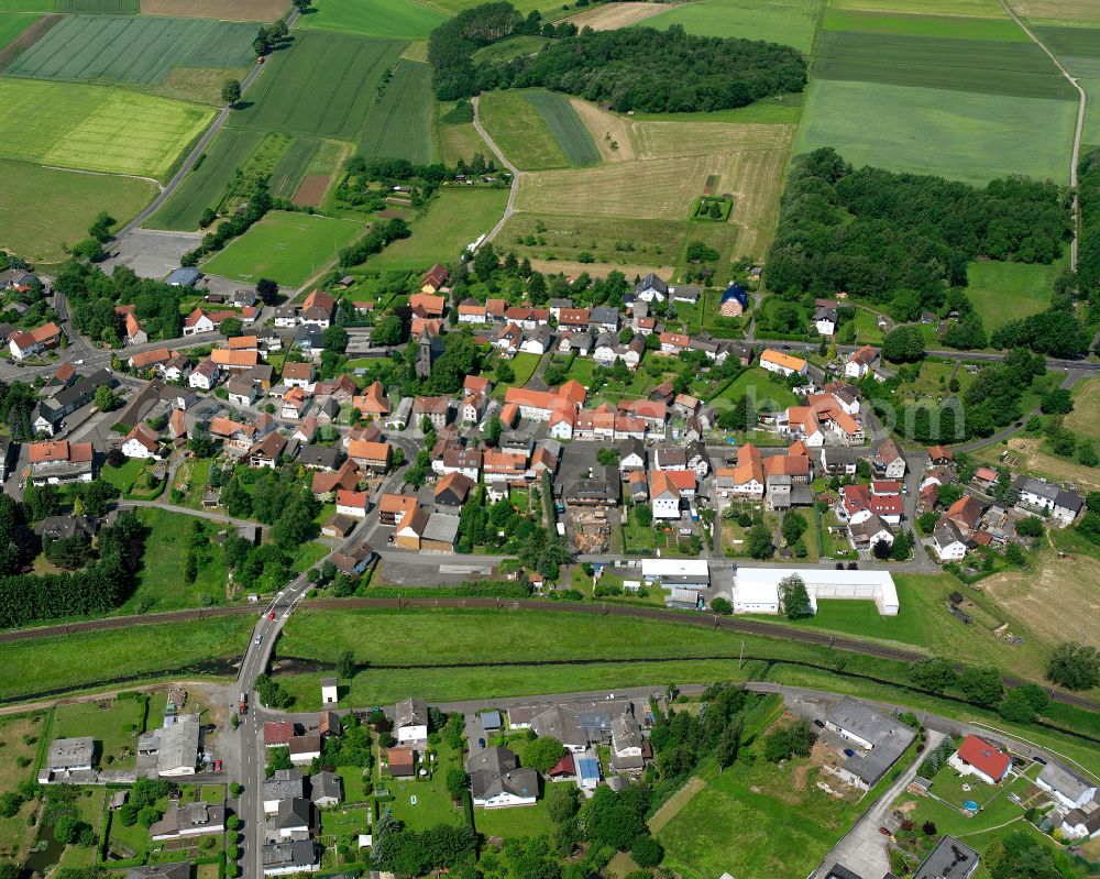 Aerial image Merlau - Agricultural land and field boundaries surround the settlement area of the village in Merlau in the state Hesse, Germany