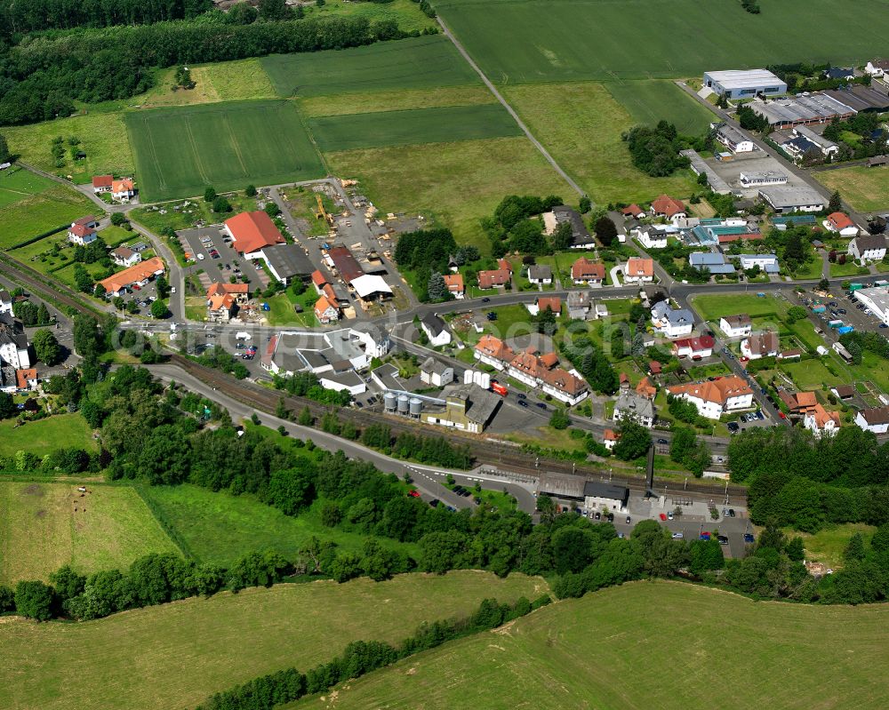 Merlau from above - Agricultural land and field boundaries surround the settlement area of the village in Merlau in the state Hesse, Germany