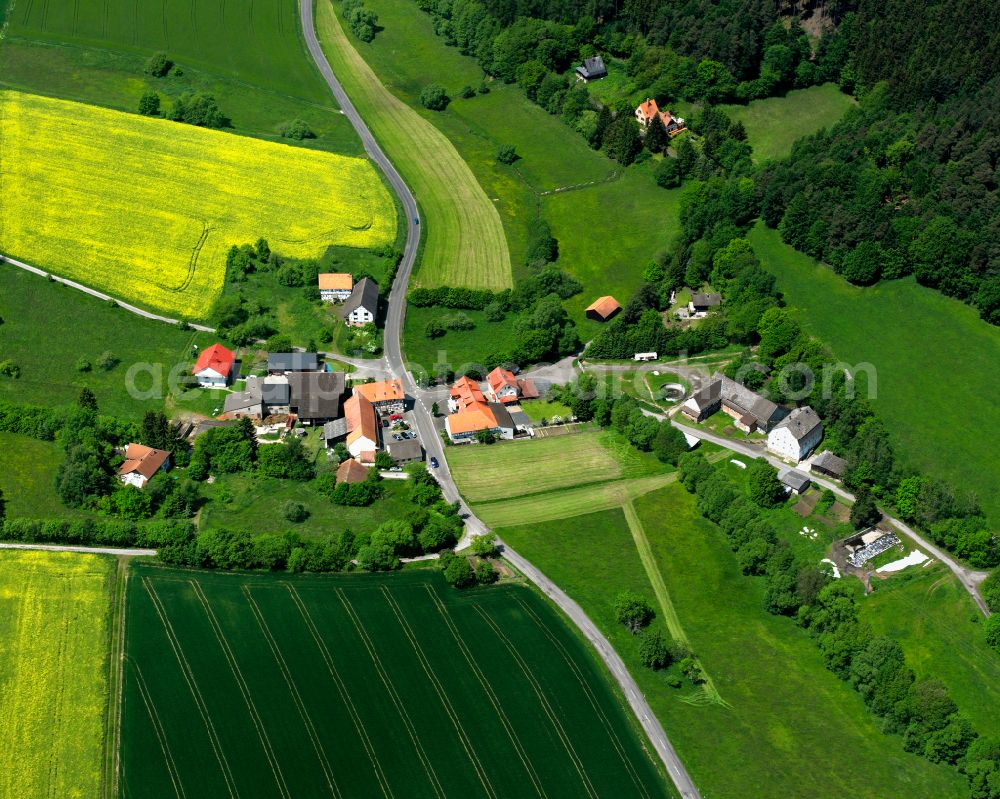 Merlos from above - Agricultural land and field boundaries surround the settlement area of the village in Merlos in the state Hesse, Germany