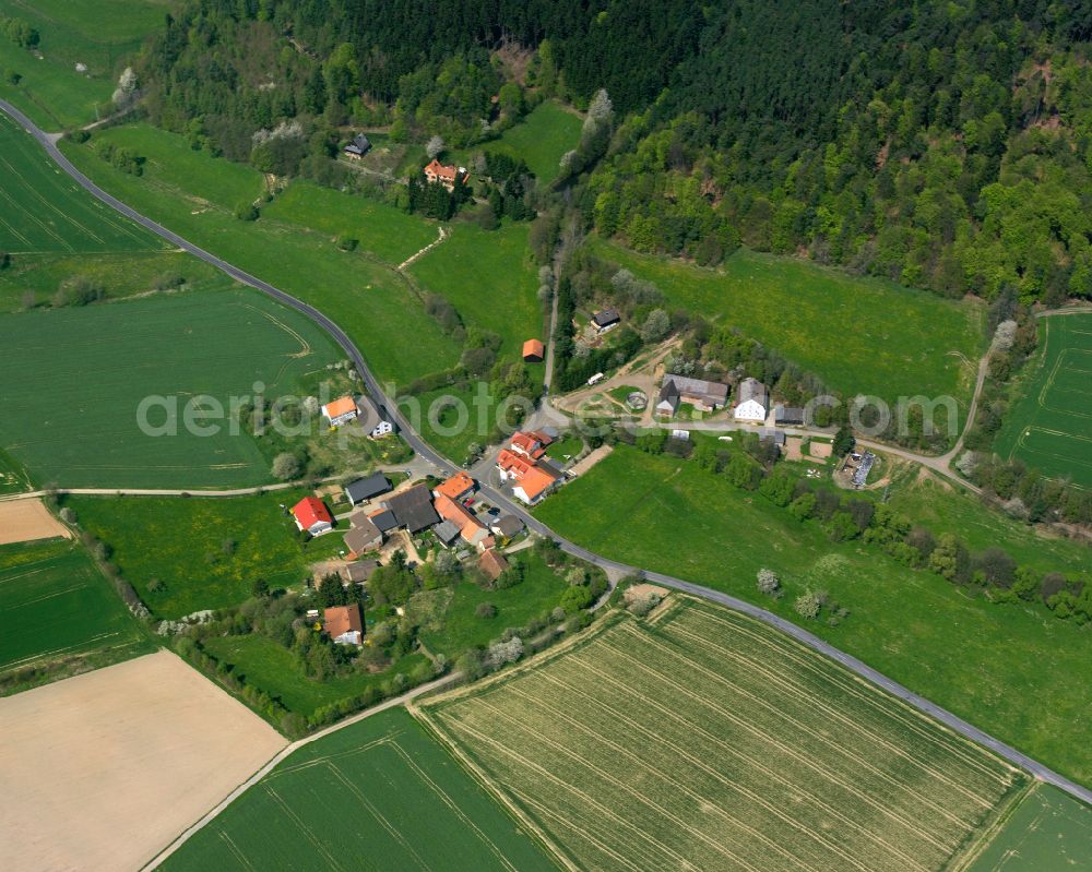 Merlos from above - Agricultural land and field boundaries surround the settlement area of the village in Merlos in the state Hesse, Germany