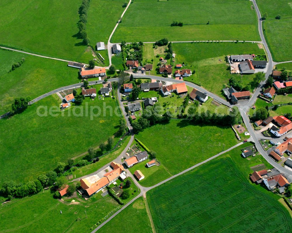 Metzlos from the bird's eye view: Agricultural land and field boundaries surround the settlement area of the village in Metzlos in the state Hesse, Germany