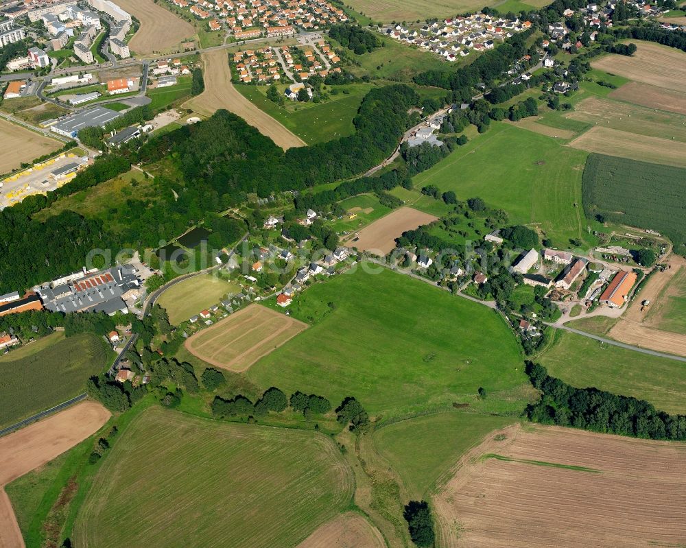 Mühlbach from above - Agricultural land and field boundaries surround the settlement area of the village in Mühlbach in the state Saxony, Germany