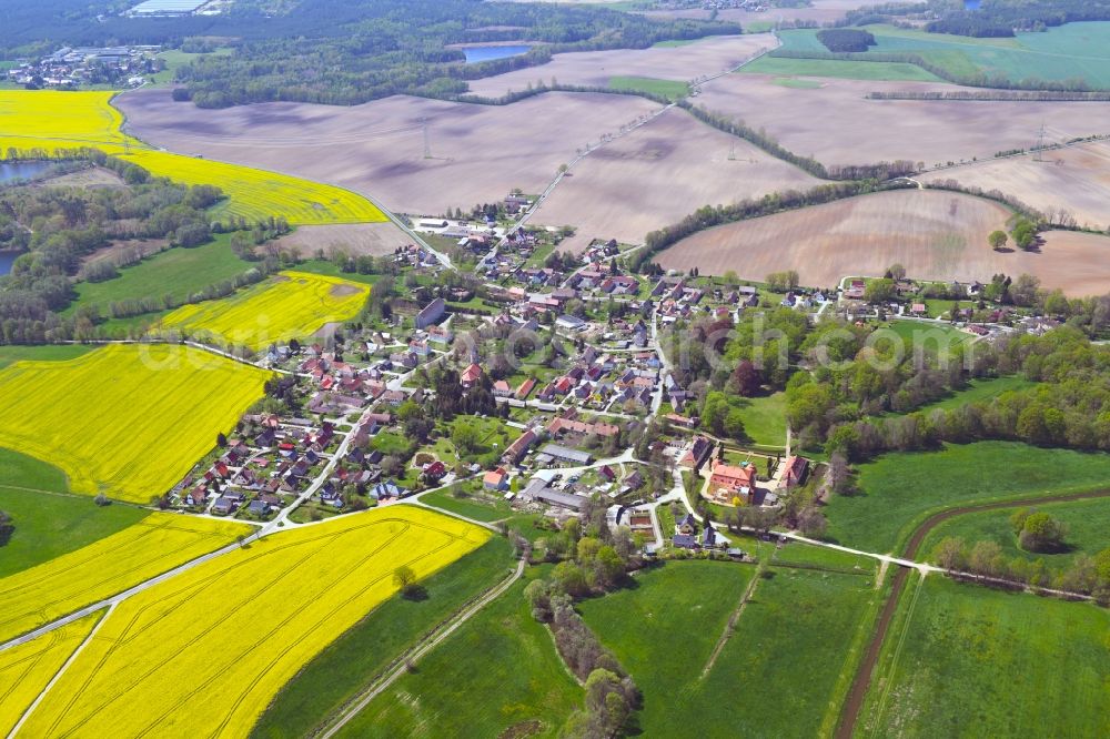 Milkel from above - Agricultural land and field boundaries surround the settlement area of the village in Milkel in the state Saxony, Germany