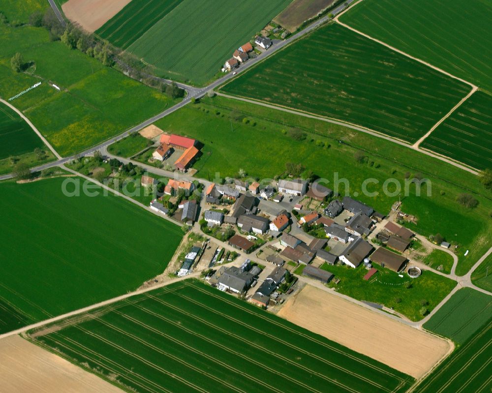 Münch-Leusel from the bird's eye view: Agricultural land and field boundaries surround the settlement area of the village in Münch-Leusel in the state Hesse, Germany