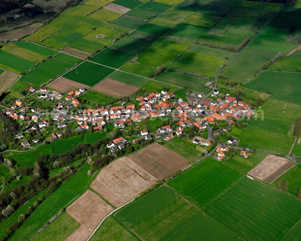 Motzfeld from the bird's eye view: Agricultural land and field boundaries surround the settlement area of the village in Motzfeld in the state Hesse, Germany