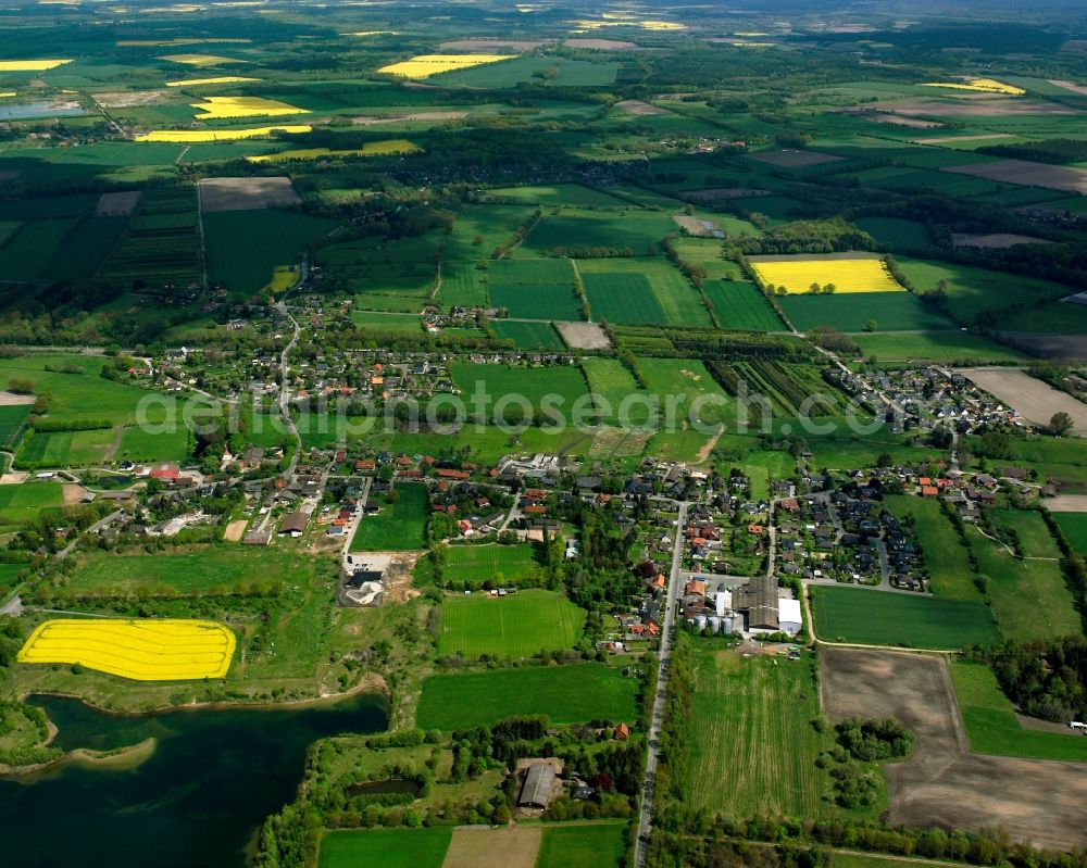 Müssen from above - Agricultural land and field boundaries surround the settlement area of the village in Müssen in the state Schleswig-Holstein, Germany