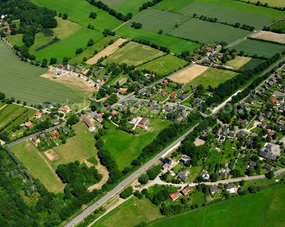 Aerial image Müssen - Agricultural land and field boundaries surround the settlement area of the village in Müssen in the state Schleswig-Holstein, Germany