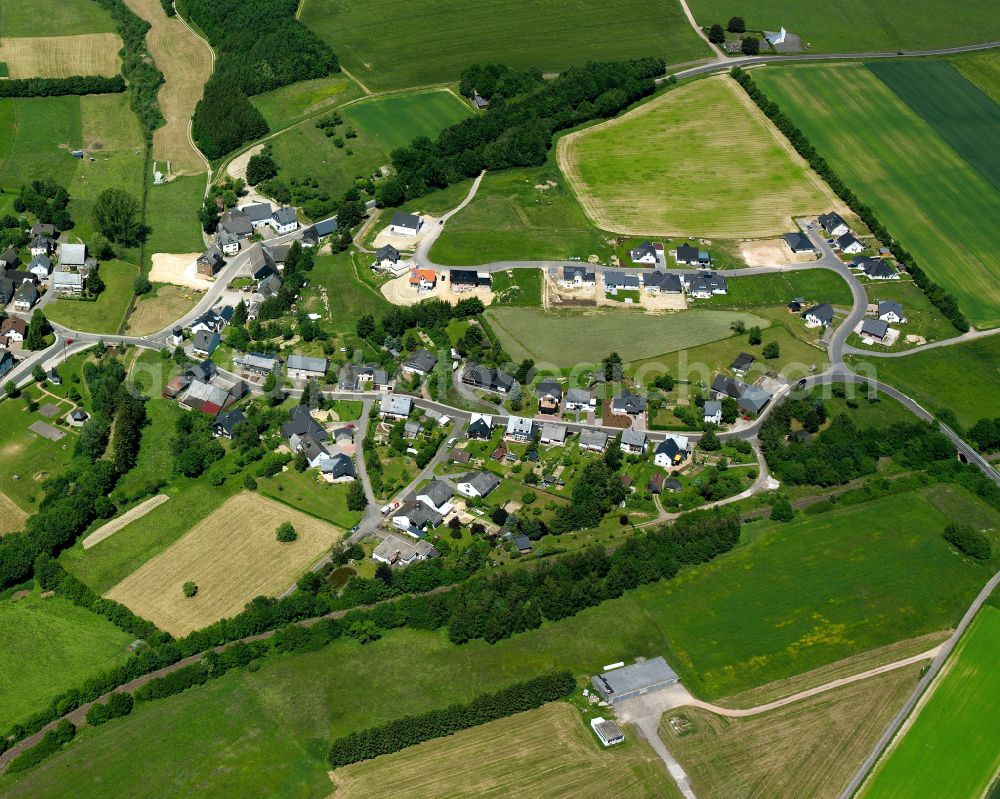 Nannhausen from above - Agricultural land and field boundaries surround the settlement area of the village in Nannhausen in the state Rhineland-Palatinate, Germany