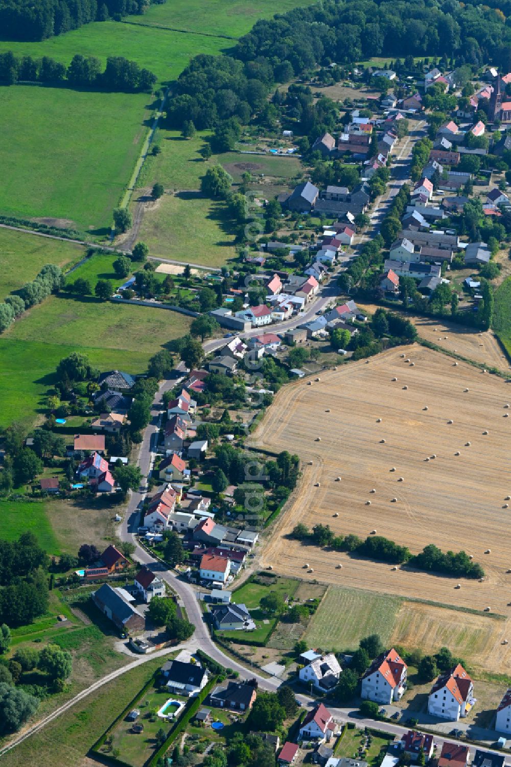 Neuschmerzke from the bird's eye view: Agricultural land and field boundaries surround the settlement area of the village in Neuschmerzke in the state Brandenburg, Germany