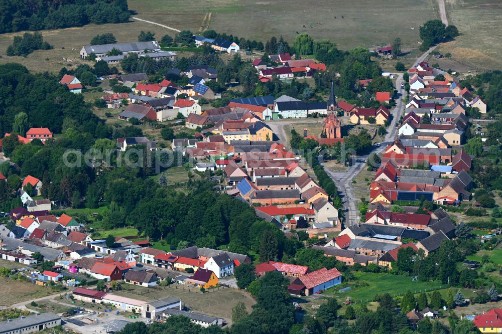 Nichel from above - Agricultural land and field boundaries surround the settlement area of the village in Nichel in the state Brandenburg, Germany