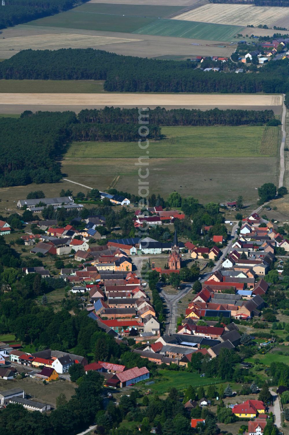 Nichel from the bird's eye view: Agricultural land and field boundaries surround the settlement area of the village in Nichel in the state Brandenburg, Germany