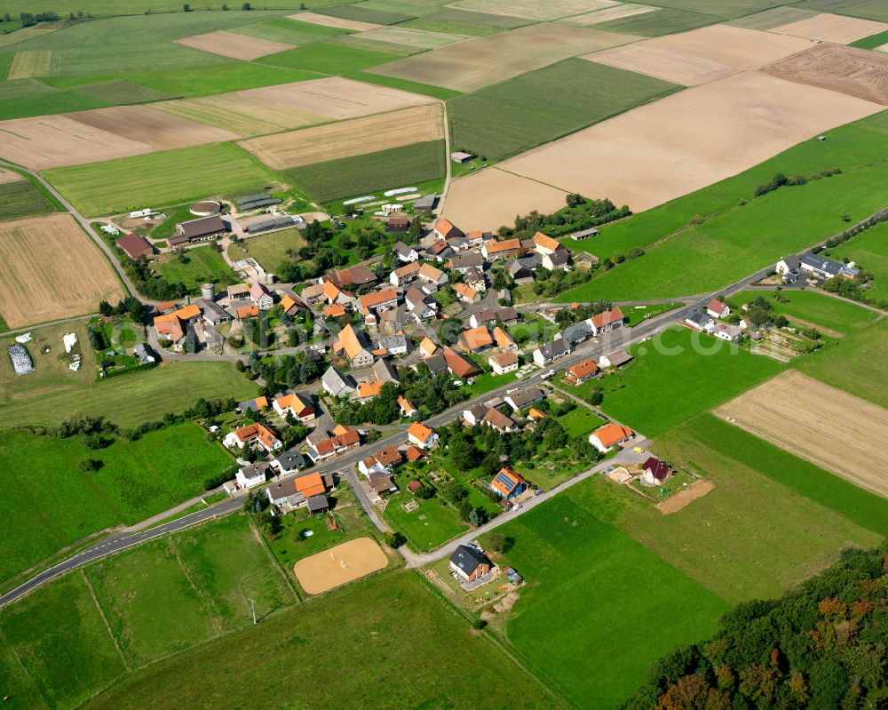 Nieder-Breidenbach from the bird's eye view: Agricultural land and field boundaries surround the settlement area of the village in Nieder-Breidenbach in the state Hesse, Germany