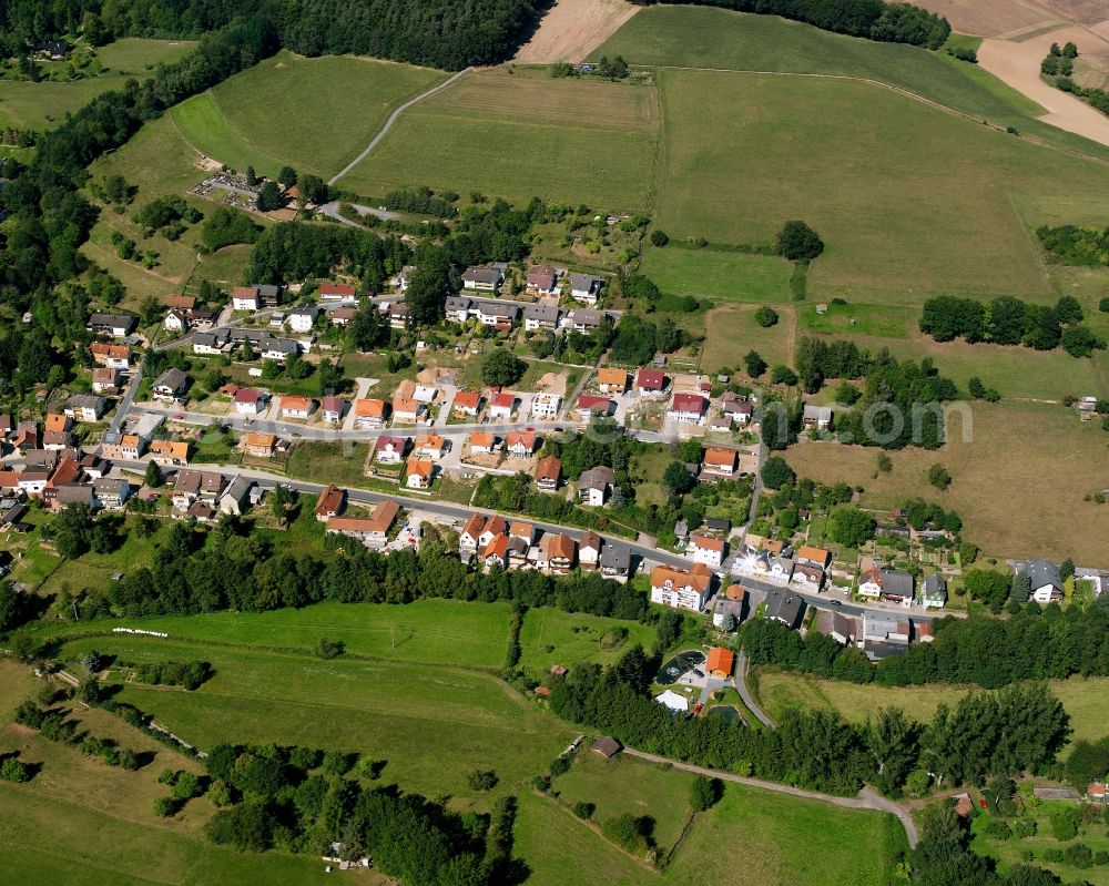 Nieder-Kinzig from above - Agricultural land and field boundaries surround the settlement area of the village in Nieder-Kinzig in the state Hesse, Germany