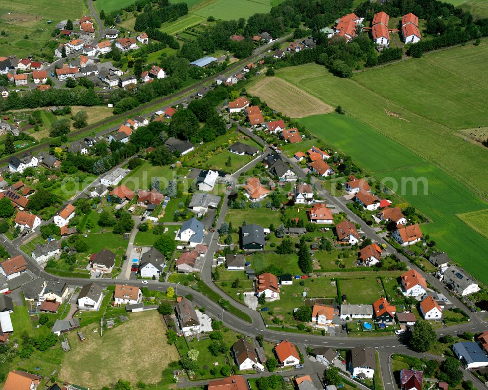 Aerial photograph Nieder-Ohmen - Agricultural land and field boundaries surround the settlement area of the village in Nieder-Ohmen in the state Hesse, Germany