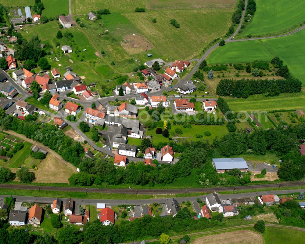 Aerial image Nieder-Ohmen - Agricultural land and field boundaries surround the settlement area of the village in Nieder-Ohmen in the state Hesse, Germany