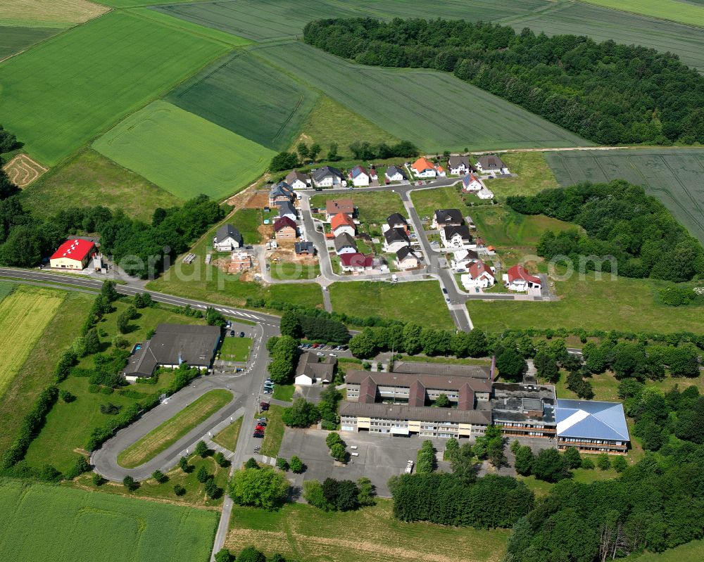 Nieder-Ohmen from the bird's eye view: Agricultural land and field boundaries surround the settlement area of the village in Nieder-Ohmen in the state Hesse, Germany