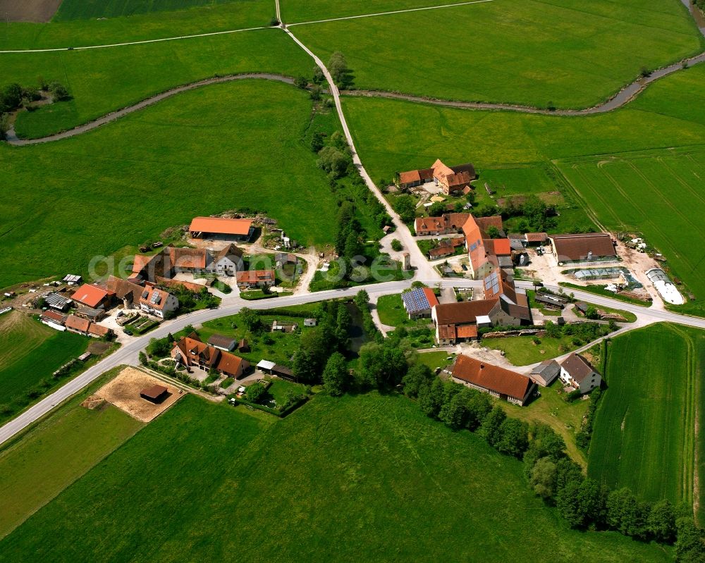 Niederdombach from above - Agricultural land and field boundaries surround the settlement area of the village in Niederdombach in the state Bavaria, Germany