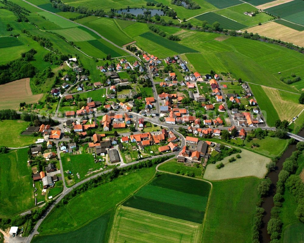 Niederellenbach from above - Agricultural land and field boundaries surround the settlement area of the village in Niederellenbach in the state Hesse, Germany