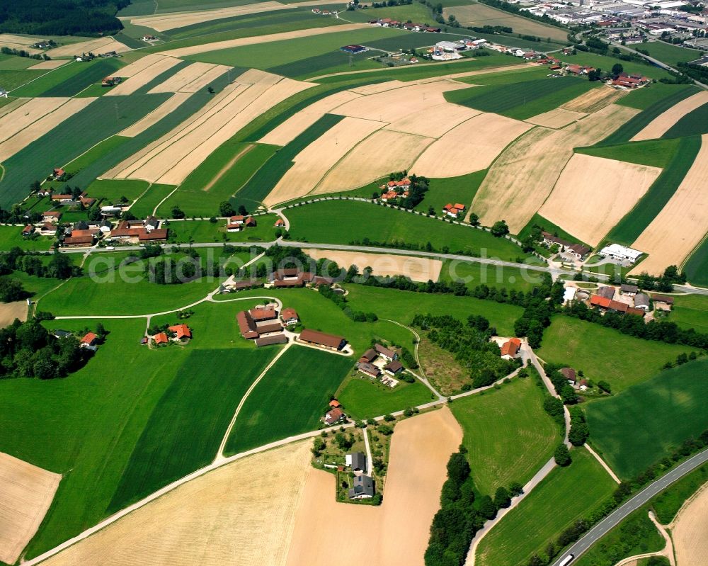 Niederndorf from the bird's eye view: Agricultural land and field boundaries surround the settlement area of the village in Niederndorf in the state Bavaria, Germany