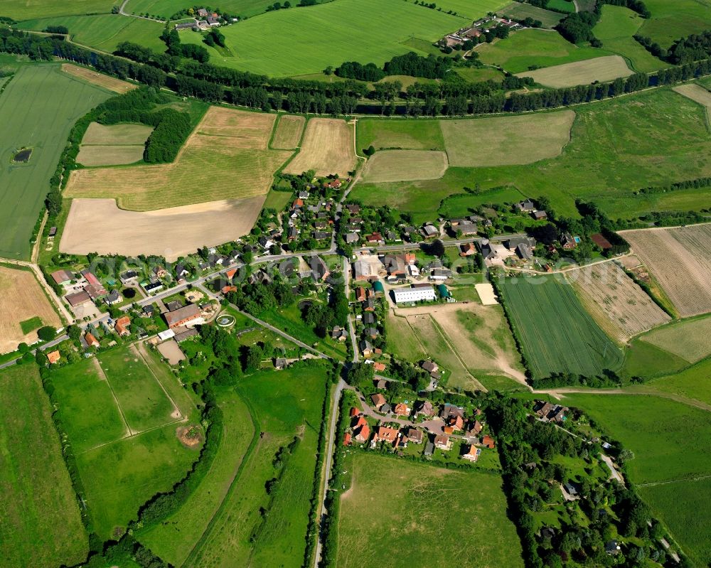 Niendorf from the bird's eye view: Agricultural land and field boundaries surround the settlement area of the village in Niendorf in the state Schleswig-Holstein, Germany