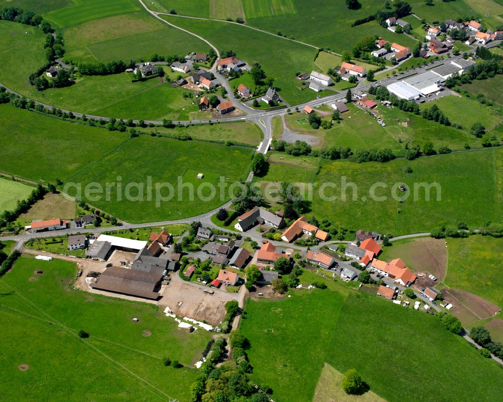 Nösberts-Weidmoos from the bird's eye view: Agricultural land and field boundaries surround the settlement area of the village in Nösberts-Weidmoos in the state Hesse, Germany