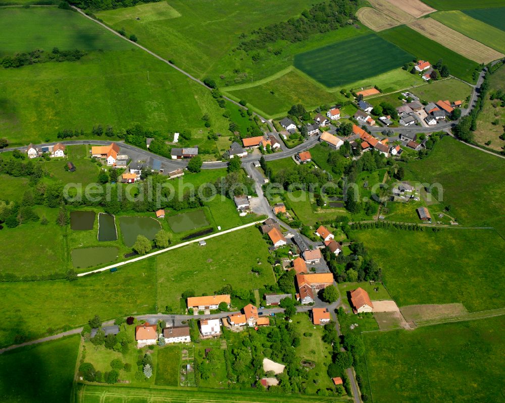 Ober-Sorg from above - Agricultural land and field boundaries surround the settlement area of the village in Ober-Sorg in the state Hesse, Germany