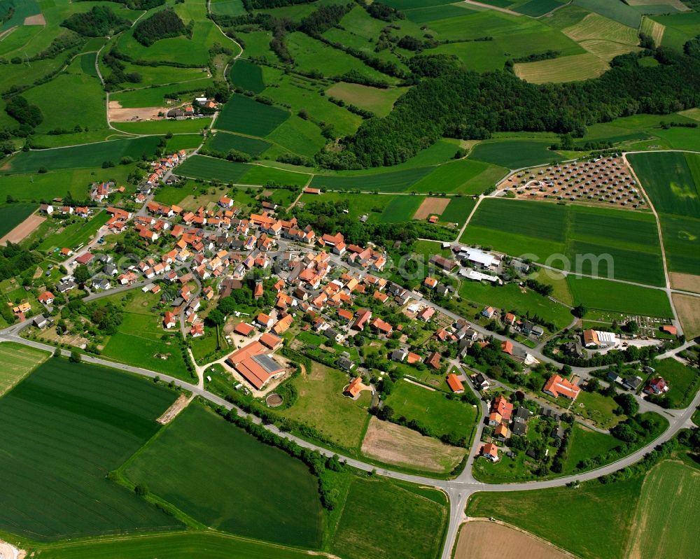 Oberellenbach from above - Agricultural land and field boundaries surround the settlement area of the village in Oberellenbach in the state Hesse, Germany