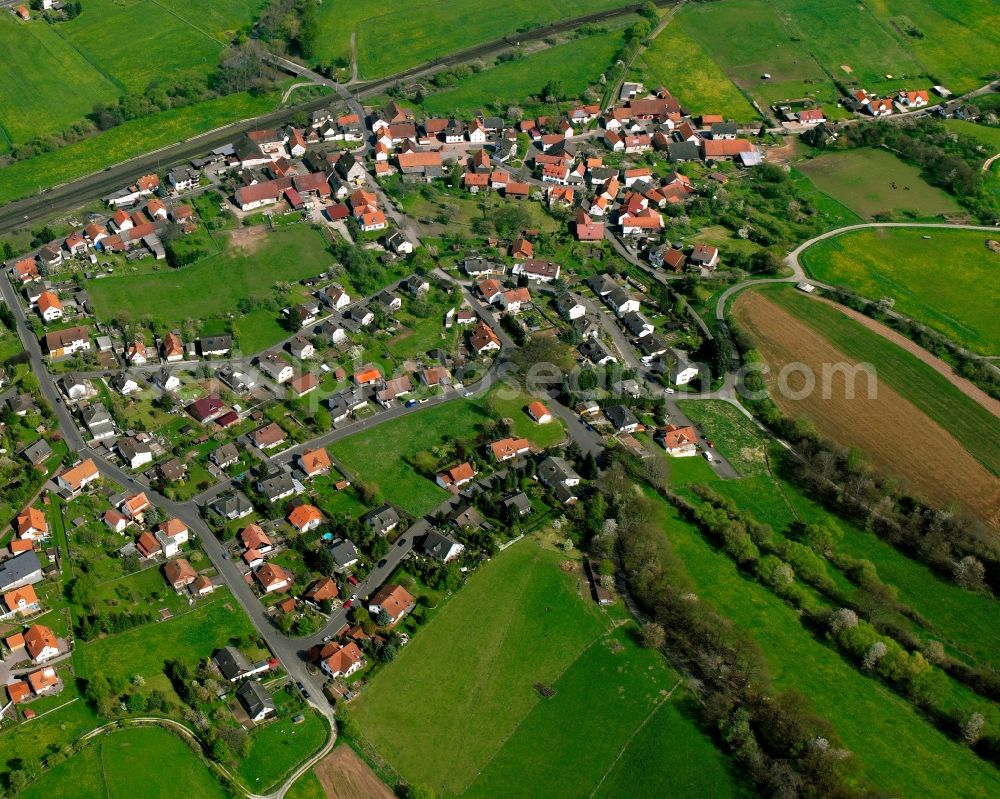 Oberhaun from above - Agricultural land and field boundaries surround the settlement area of the village in Oberhaun in the state Hesse, Germany