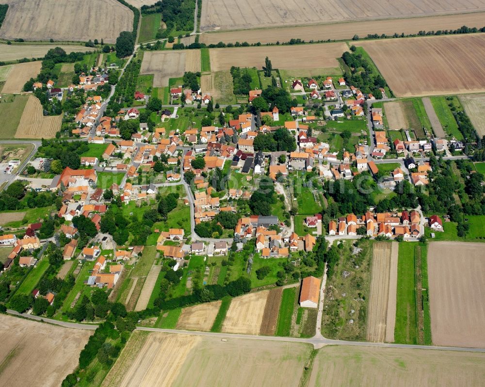 Obermehler from above - Agricultural land and field boundaries surround the settlement area of the village in Obermehler in the state Thuringia, Germany