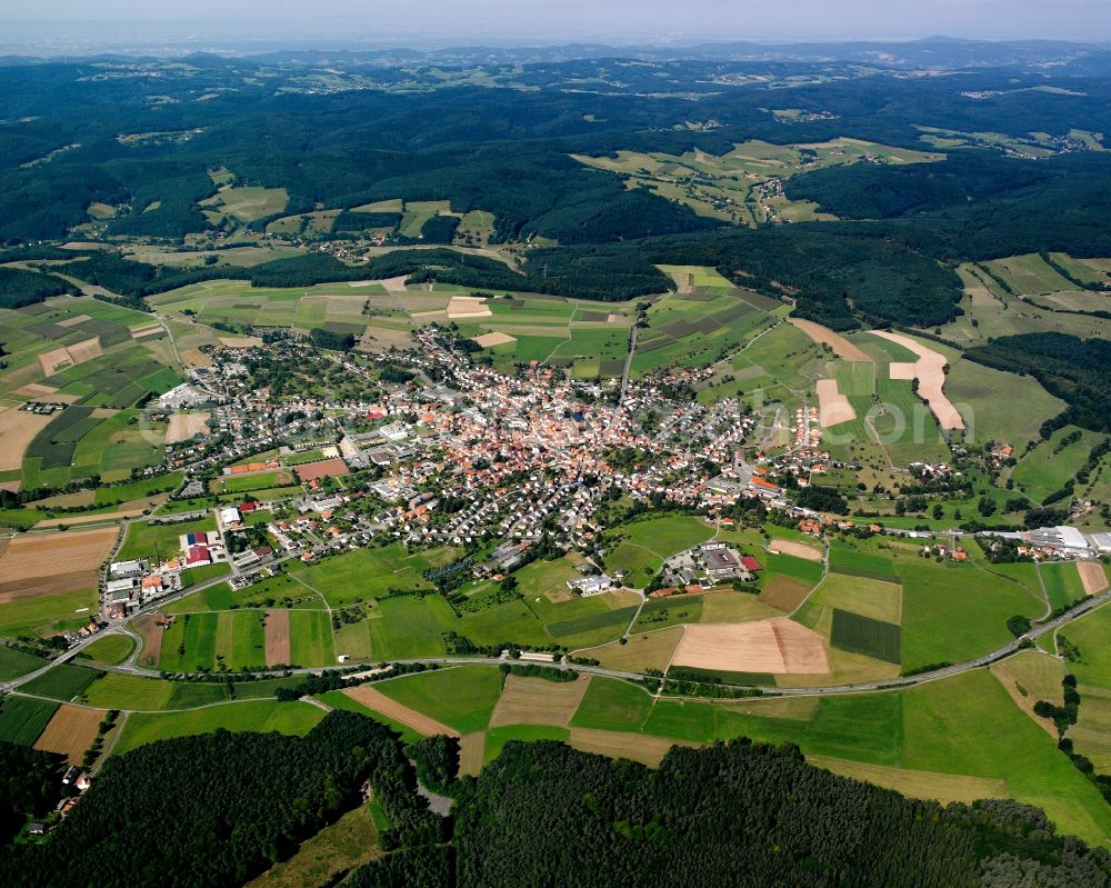 Oberzent from above - Agricultural land and field boundaries surround the settlement area of the village in Oberzent in the state Hesse, Germany