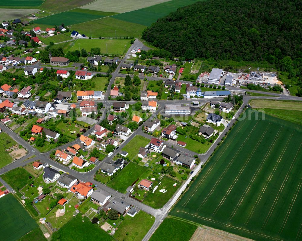 Ohmes from above - Agricultural land and field boundaries surround the settlement area of the village in Ohmes in the state Hesse, Germany