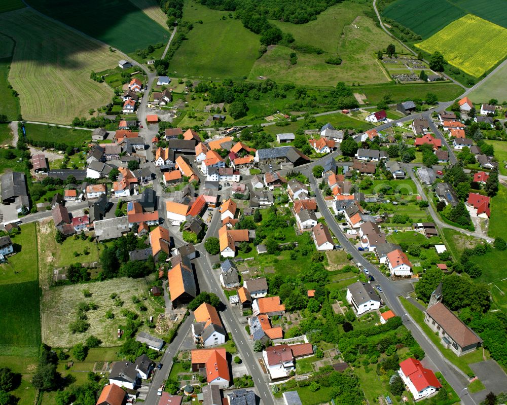 Ohmes from the bird's eye view: Agricultural land and field boundaries surround the settlement area of the village in Ohmes in the state Hesse, Germany