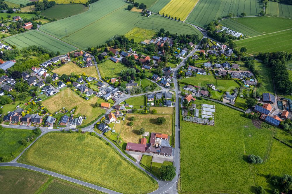 Osttünnen from the bird's eye view: Agricultural land and field boundaries surround the settlement area of the village in Osttünnen in the state North Rhine-Westphalia, Germany