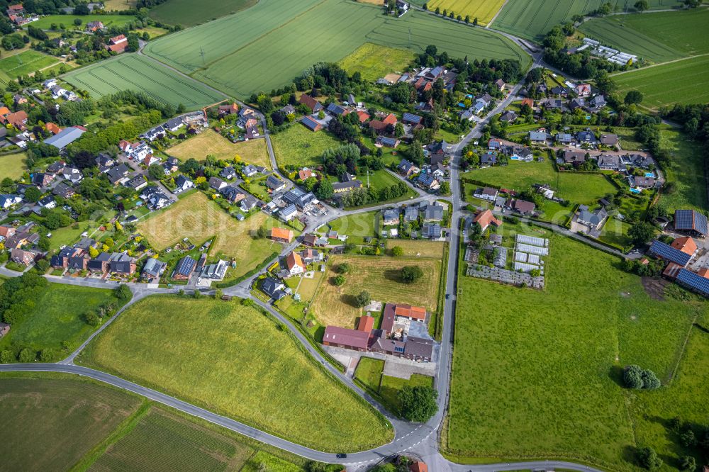 Osttünnen from above - Agricultural land and field boundaries surround the settlement area of the village in Osttünnen in the state North Rhine-Westphalia, Germany