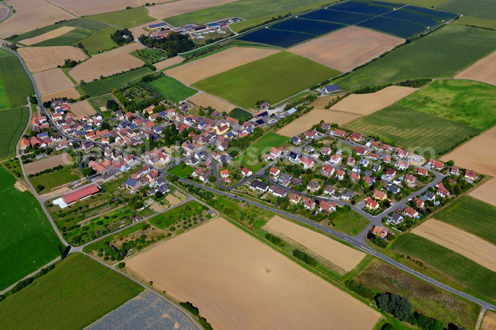 Püssensheim from above - Agricultural land and field boundaries surround the settlement area of the village in Püssensheim in the state Bavaria, Germany