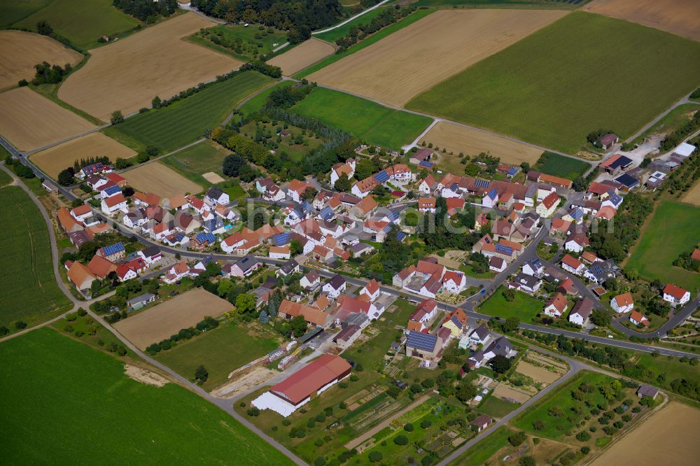 Püssensheim from the bird's eye view: Agricultural land and field boundaries surround the settlement area of the village in Püssensheim in the state Bavaria, Germany