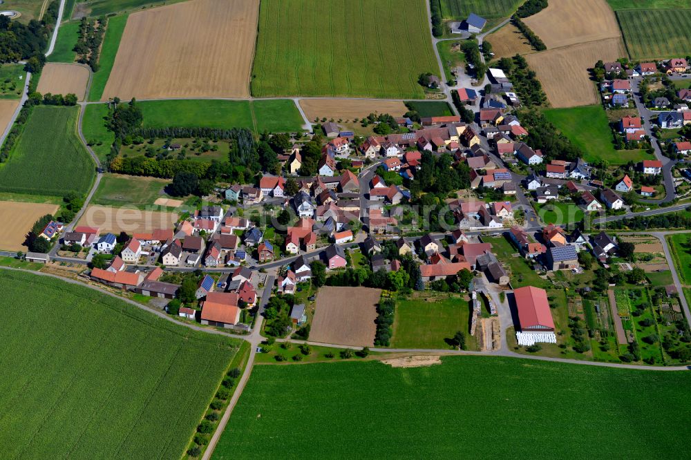 Aerial photograph Püssensheim - Agricultural land and field boundaries surround the settlement area of the village in Püssensheim in the state Bavaria, Germany