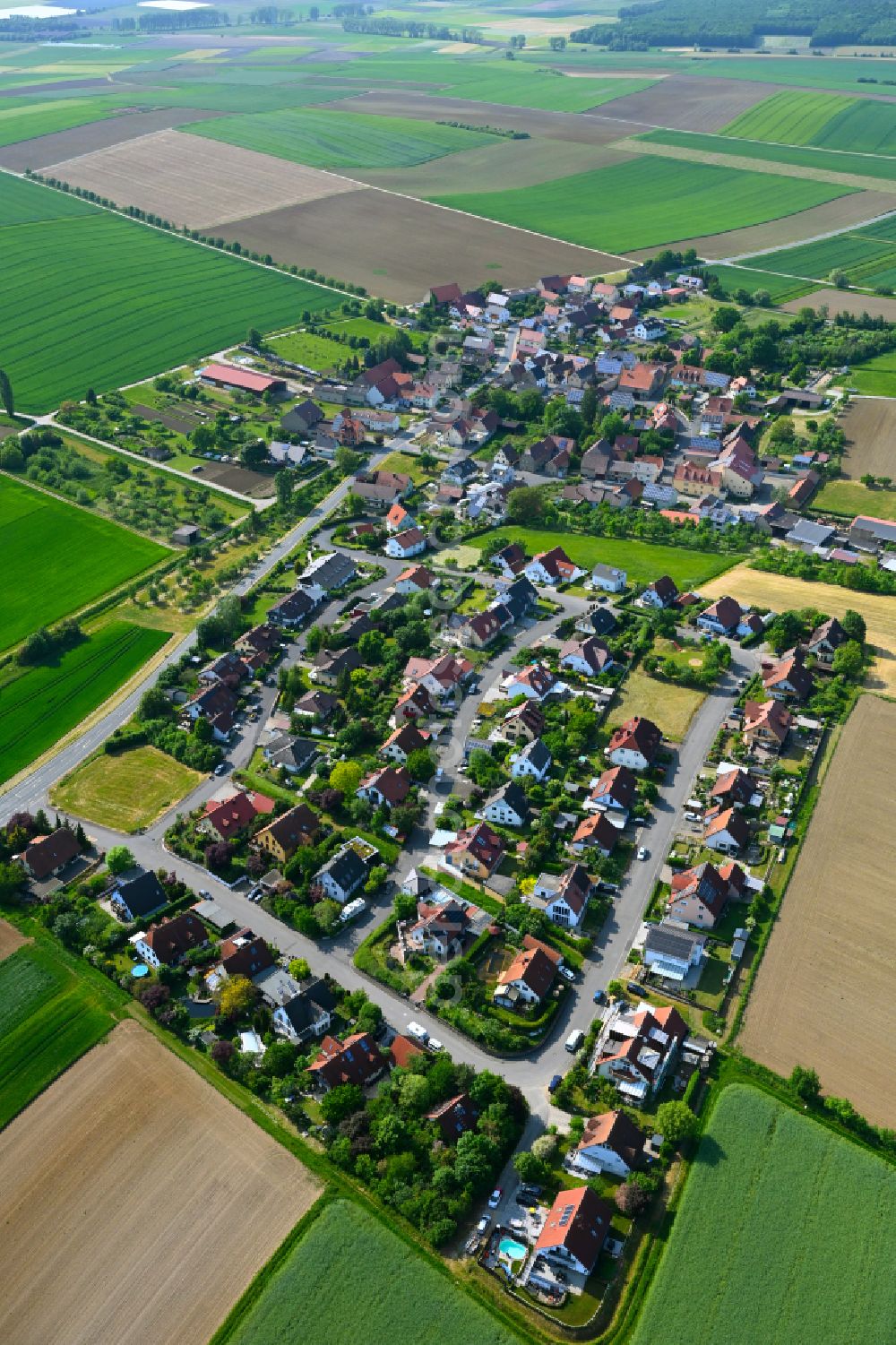 Püssensheim from above - Agricultural land and field boundaries surround the settlement area of the village in Püssensheim in the state Bavaria, Germany