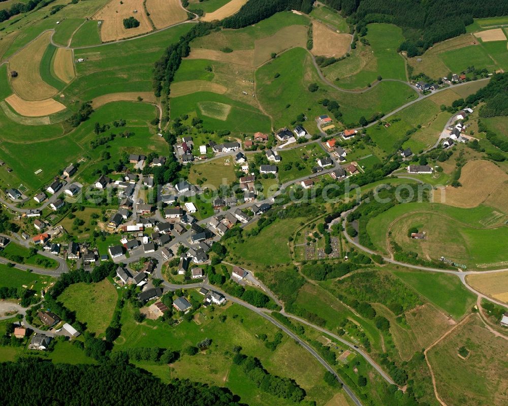 Puderbach from above - Agricultural land and field boundaries surround the settlement area of the village in Puderbach in the state North Rhine-Westphalia, Germany