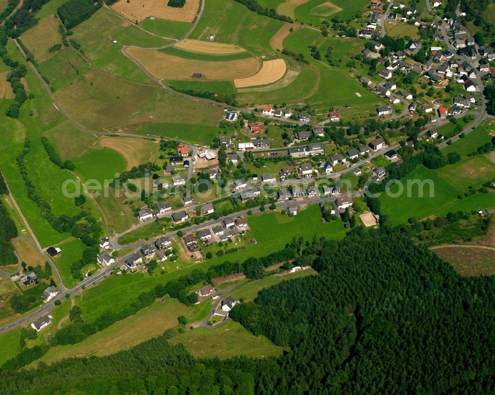 Puderbach from the bird's eye view: Agricultural land and field boundaries surround the settlement area of the village in Puderbach in the state North Rhine-Westphalia, Germany